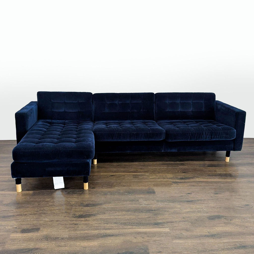Deep navy blue IKEA sectional with tufted velvet upholstery and chaise, offering modern style and spacious comfort.
