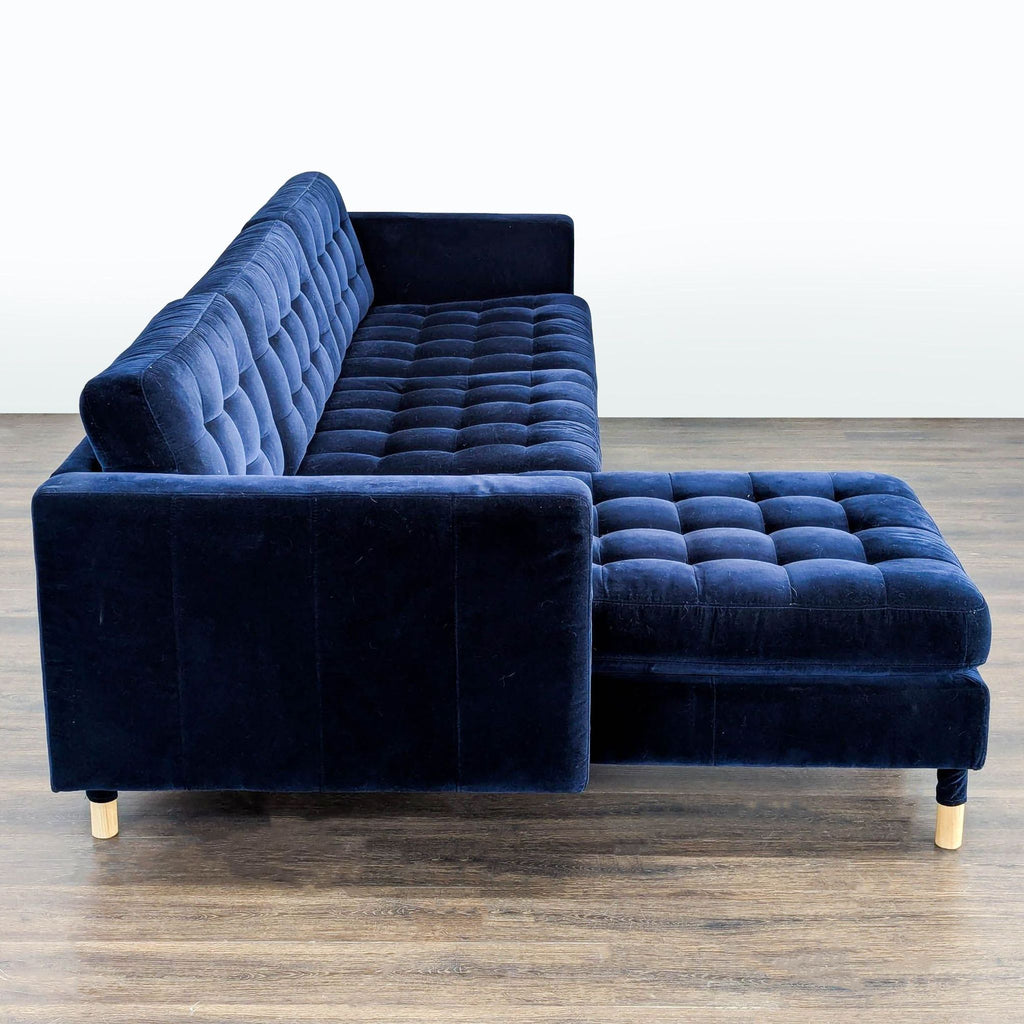 Tufted navy blue IKEA chaise sectional, plush velvet fabric, wooden legs, ideal for stylish, cozy living room seating.