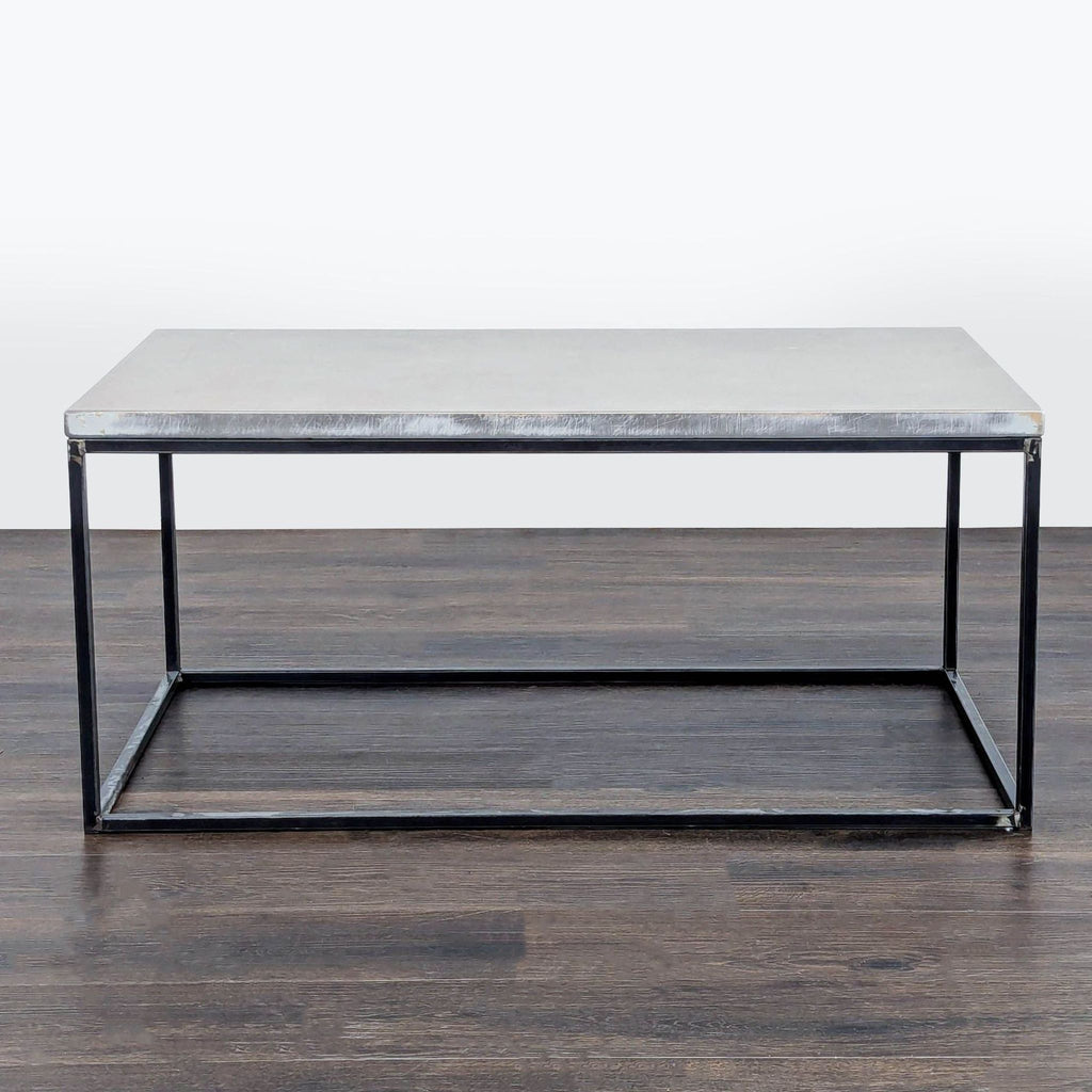 1. Minimalist coffee table with a rectangular concrete top and black metal frame, shown on dark wood floor.
