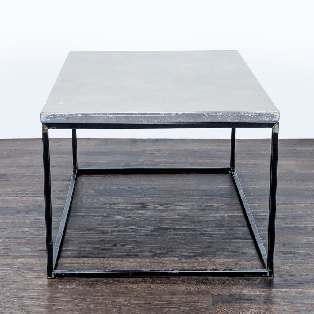 3. Industrial style coffee table with a solid concrete top and open metal base, viewed from the end.
