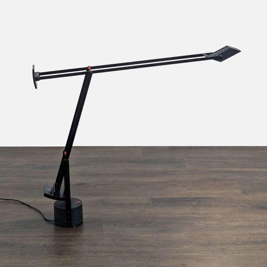 Modern Artemide lighting: black desk lamp with adjustable arm design, offering practical style for any desk.