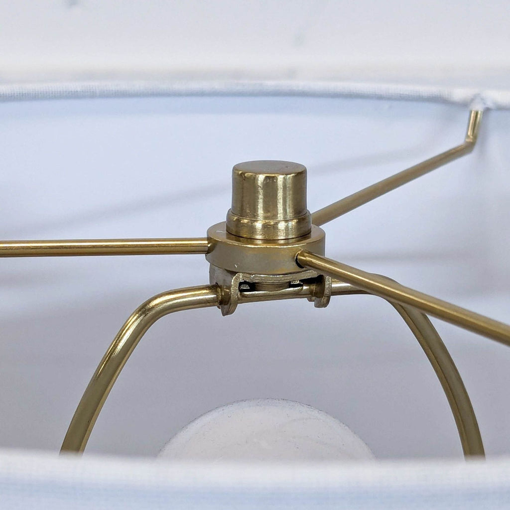 3. Close-up of the brass fixture inside a West Elm lamp’s shade, showing sturdy metal supports and connection details.