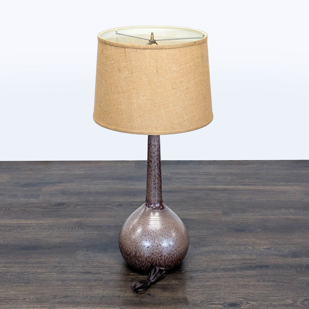 Contemporary lighting: ceramic table lamp featuring unique glaze, rounded shape, and a neutral fabric shade.