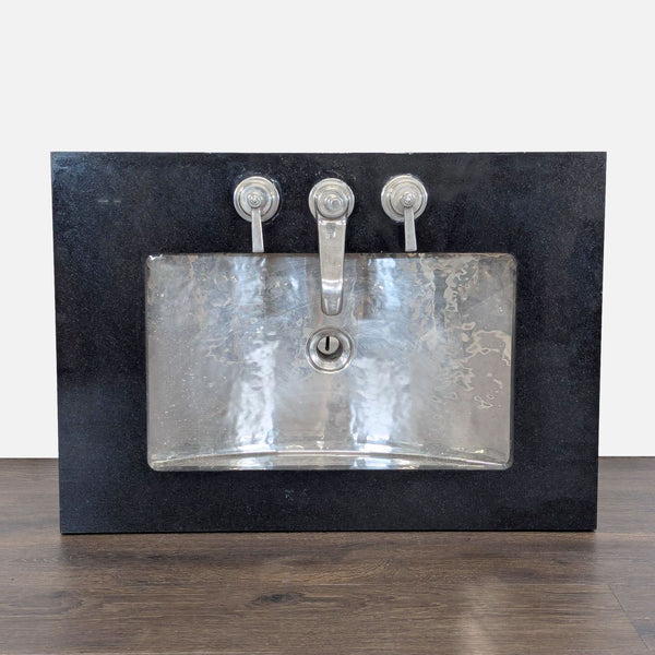 Hammered nickel Waterworks sink with black stone backplate and three-piece faucet, modern bathroom style.