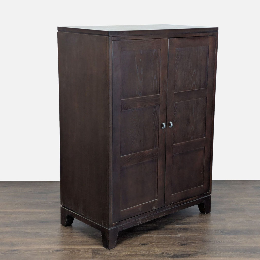 3. Angled view of a dark wood Ethan Allen cabinet with two paneled doors and short, sturdy legs.