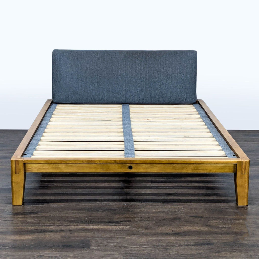 Thuma solid wood bed frame with upholstered gray headboard and sturdy slat support shown in modern bedroom.  