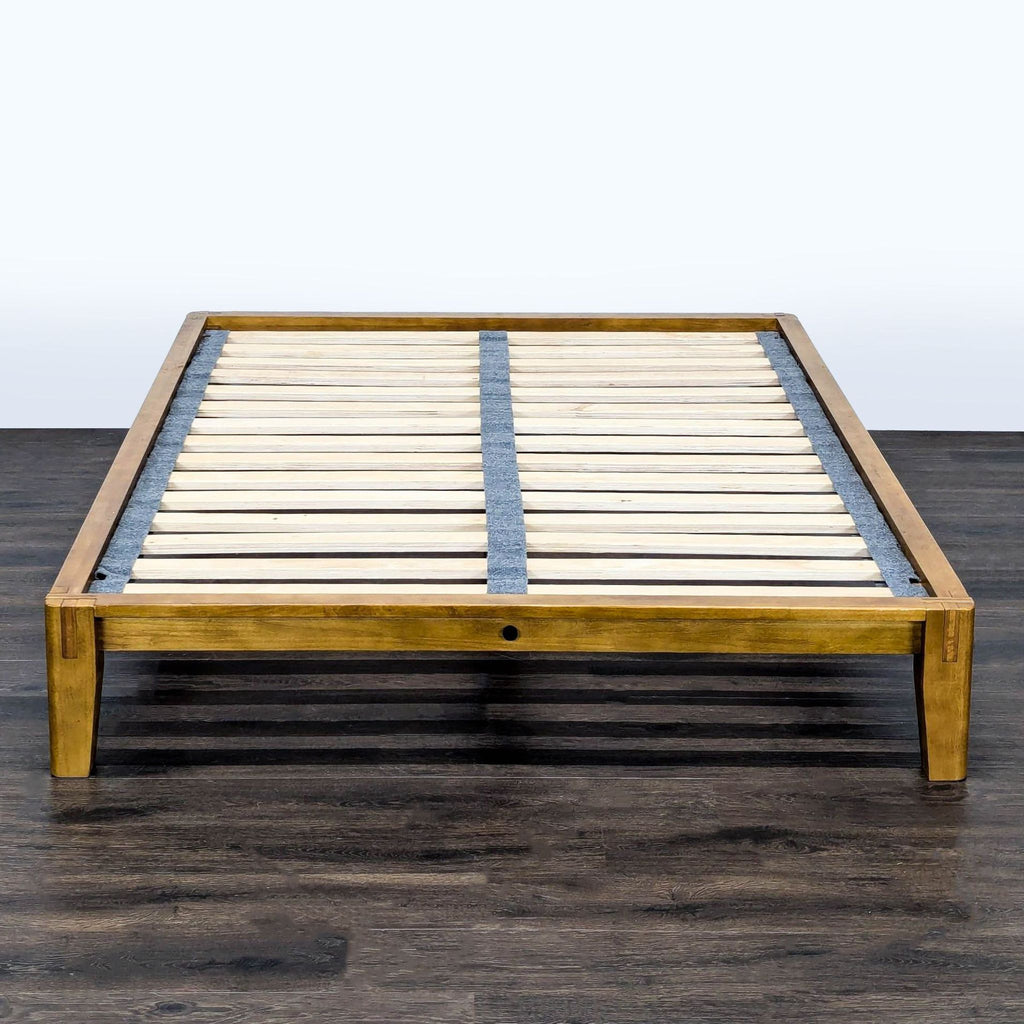 Modern Thuma bed frame in solid wood, featuring slatted base and gray fabric headboard for style and comfort.