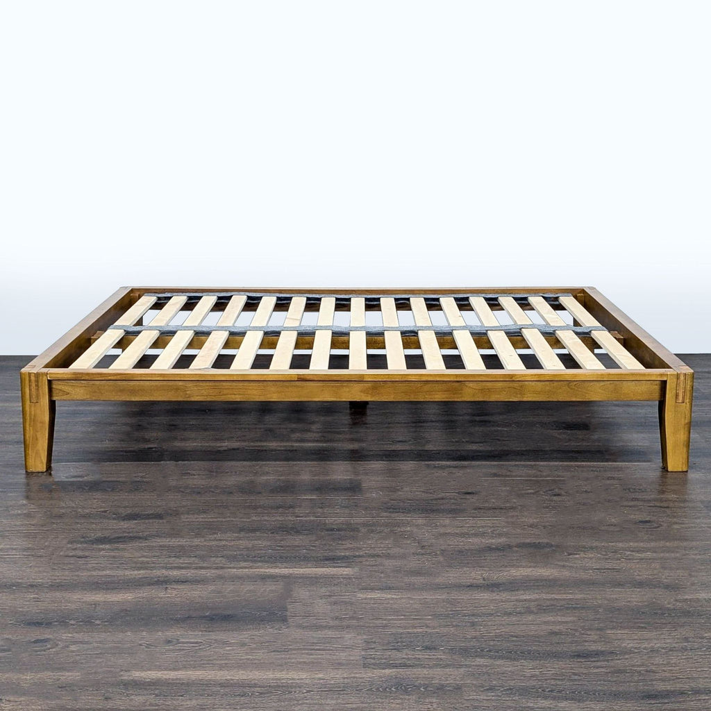 Minimalist Thuma Frame bed with neutral gray headboard, robust wooden construction, and simple, timeless design.  