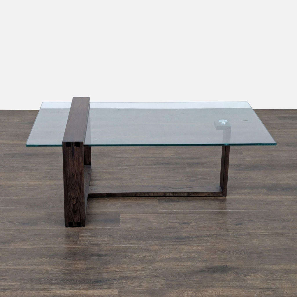 Modern coffee table by Living Spaces, featuring a sturdy Mindi wood base and clear glass top.