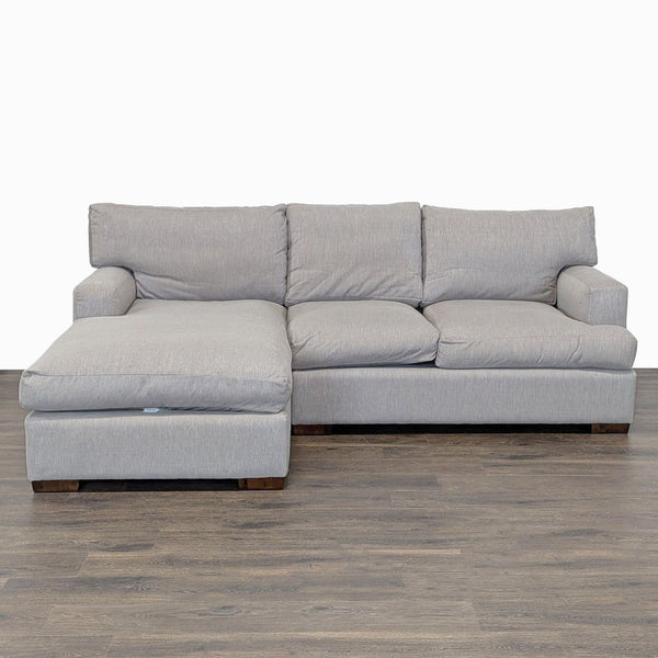 Modern light gray L-shaped sectional sofa with plush cushions and chaise lounge for ample comfort and seating.