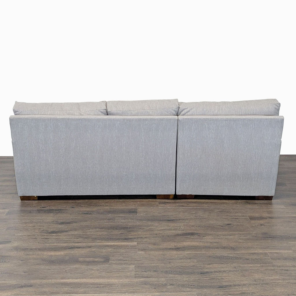 Contemporary sectional with a relaxed L-shape, wide armrests, and cozy gray upholstery—ideal for family gatherings.