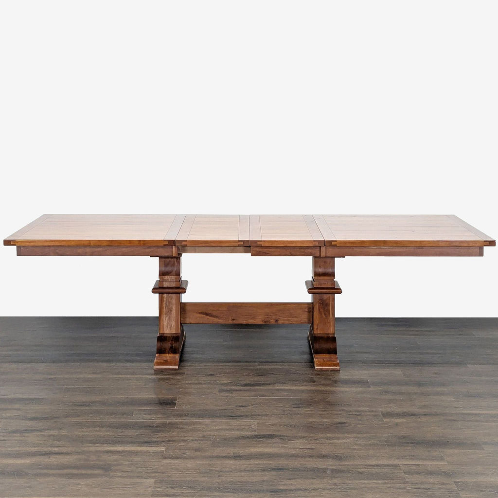 Dining table by Amish Tables featuring trestle base and storage for two expansion leaves, shown extended.