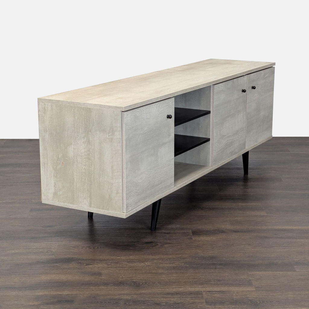 3. Angled view of Carson Carrington entertainment center, highlighting sleek legs and multiple storage compartments.