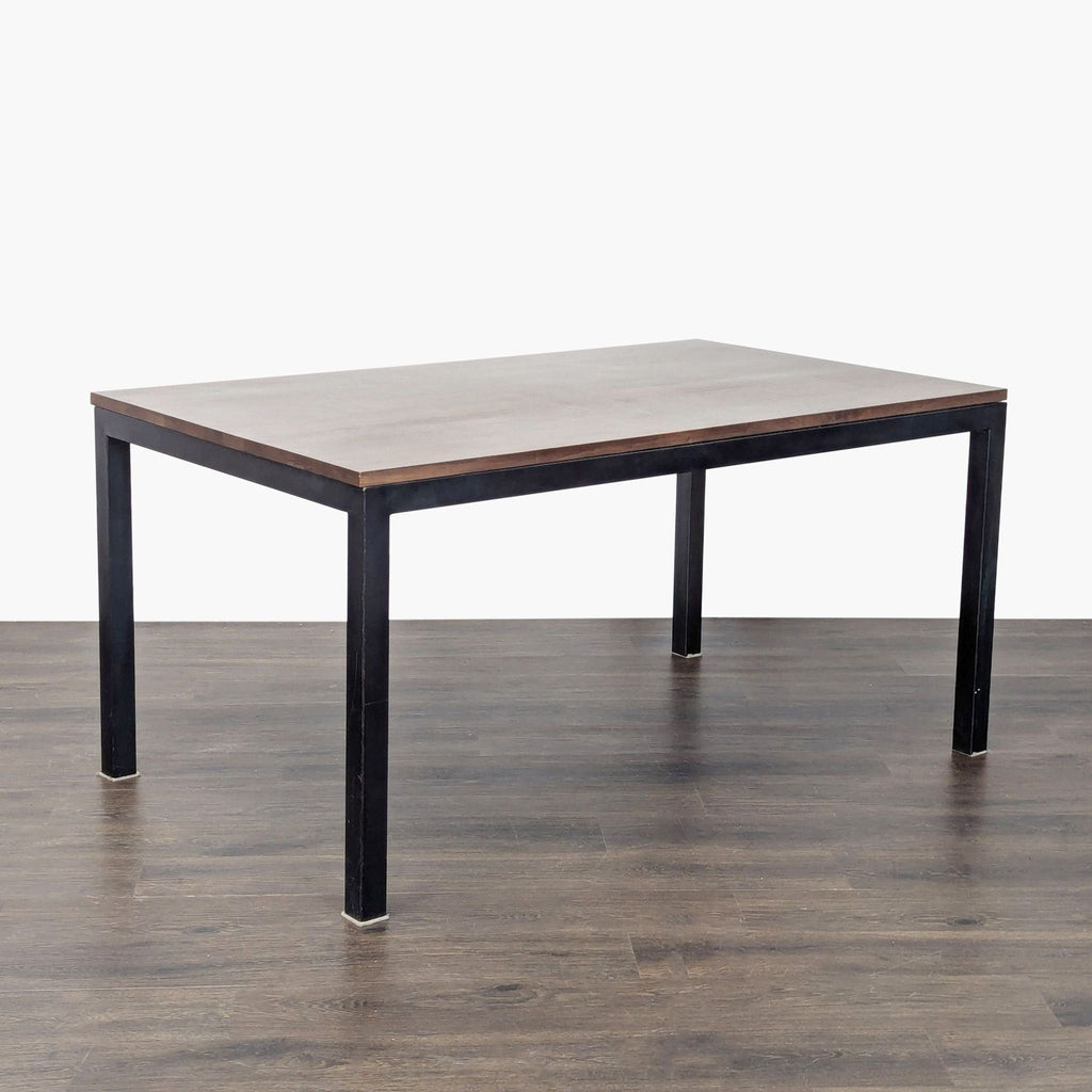 Modern dining table featuring a wood surface and metal base by Crate & Barrel.  