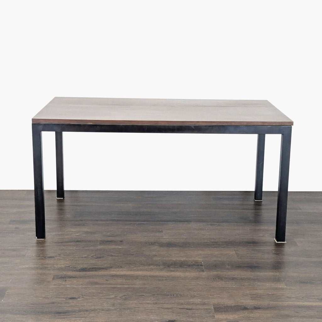 Sleek steel-base dining table with a wood top, ideal for contemporary spaces; Crate & Barrel brand.