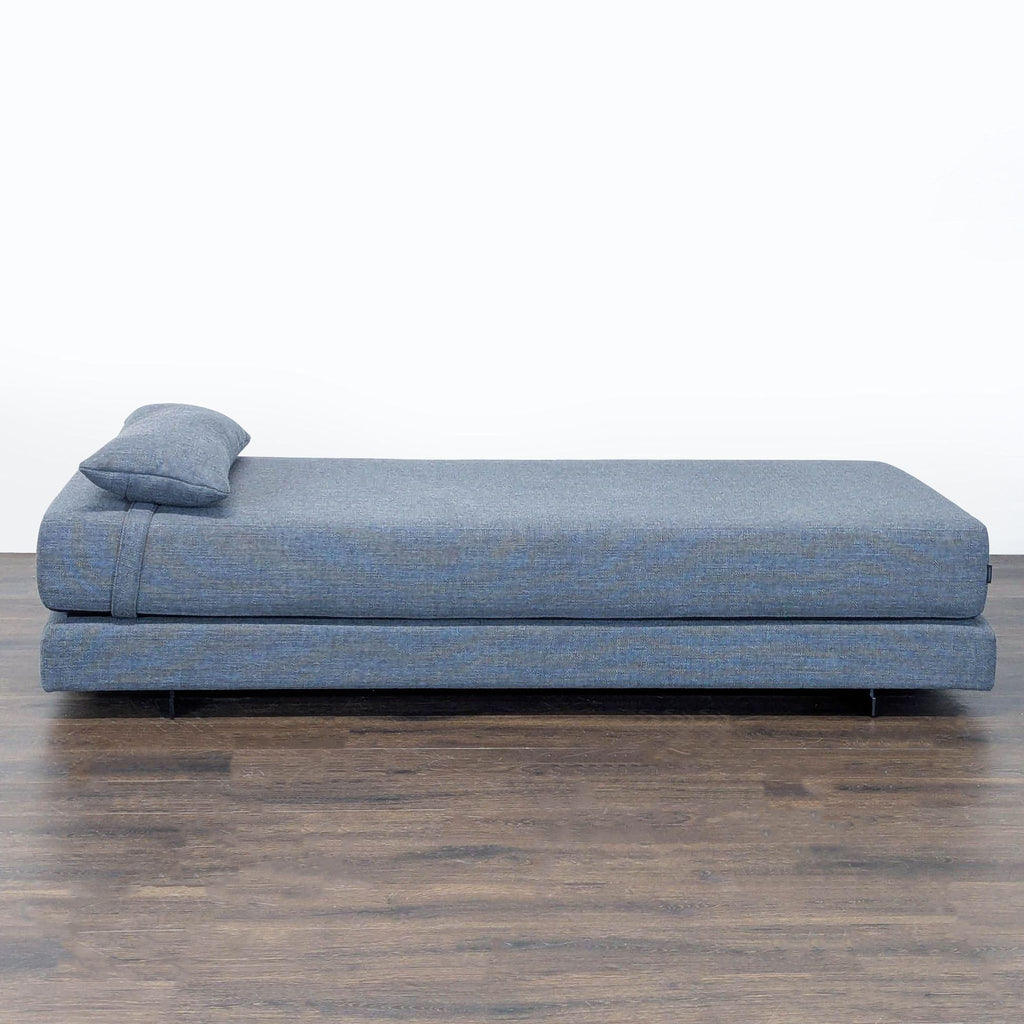 Softline blue daybed sofa with matching pillow, convertible to two twin beds, modern and versatile design.