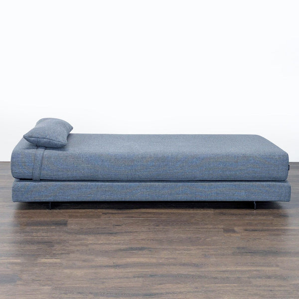 Softline blue daybed sofa with matching pillow, convertible to two twin beds, modern and versatile design.