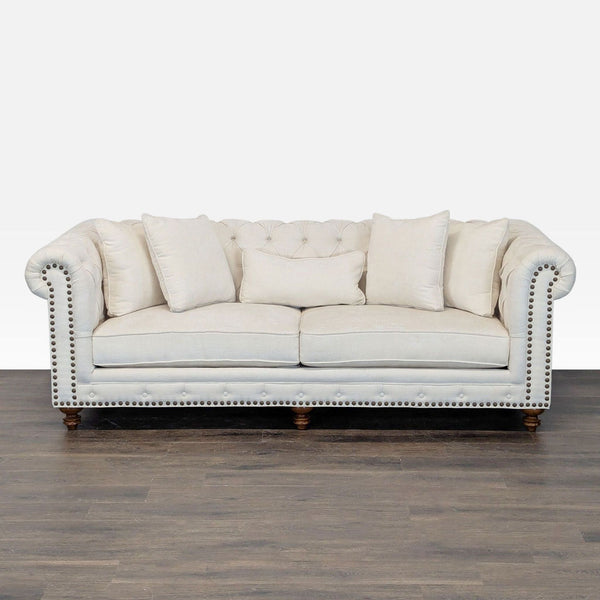 Elegant cream 3-seat Chesterfield sofa with button tufting, rolled arms, and nailhead trim for stylish comfort.