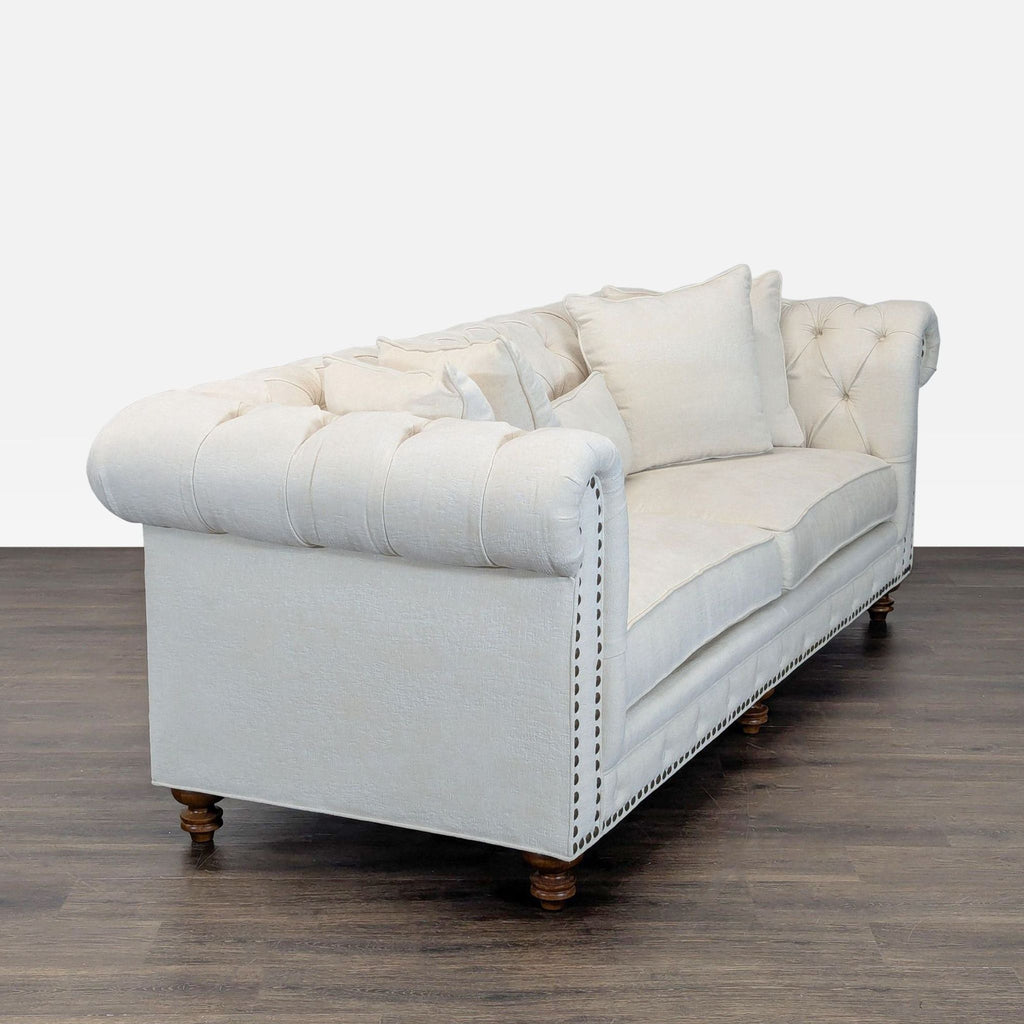 Cream upholstered 3-seat sofa featuring classic button tufting, plush cushions, and matching throw pillows.