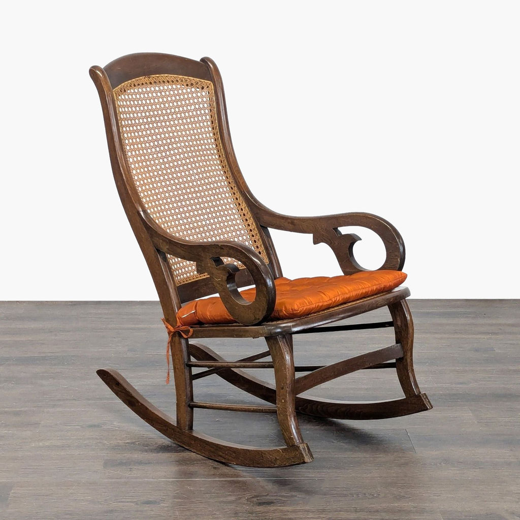 Vintage-style rocking chair with a sturdy frame, cane design, and plush orange cushion, perfect for any room.