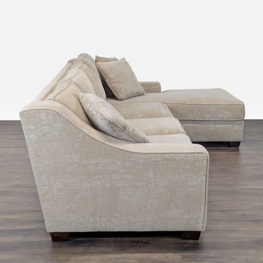 Comfortable beige sectional with a chaise lounge and throw pillows, offering stylish, ample seating for guests.