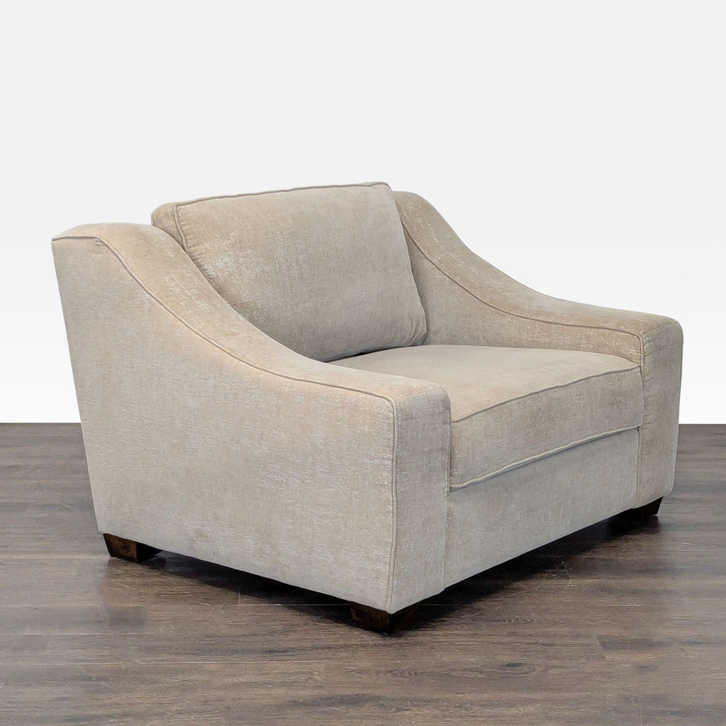 Spacious beige lounge chair offering thick cushioning, armrests, and a modern look that fits any lounge area.