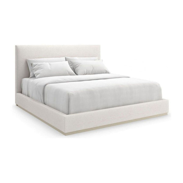 Caracole upholstered bed frame featuring a clean, modern design with a soft finish, shown without bedding.