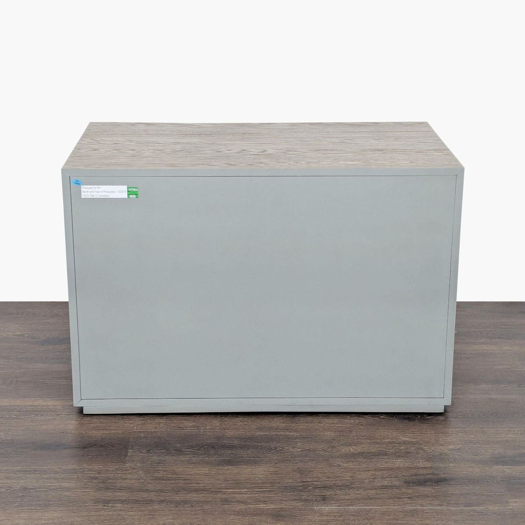 3. Back view of a Restoration Hardware end table, showcasing a smooth, flat gray panel with visible oak wood top edge.