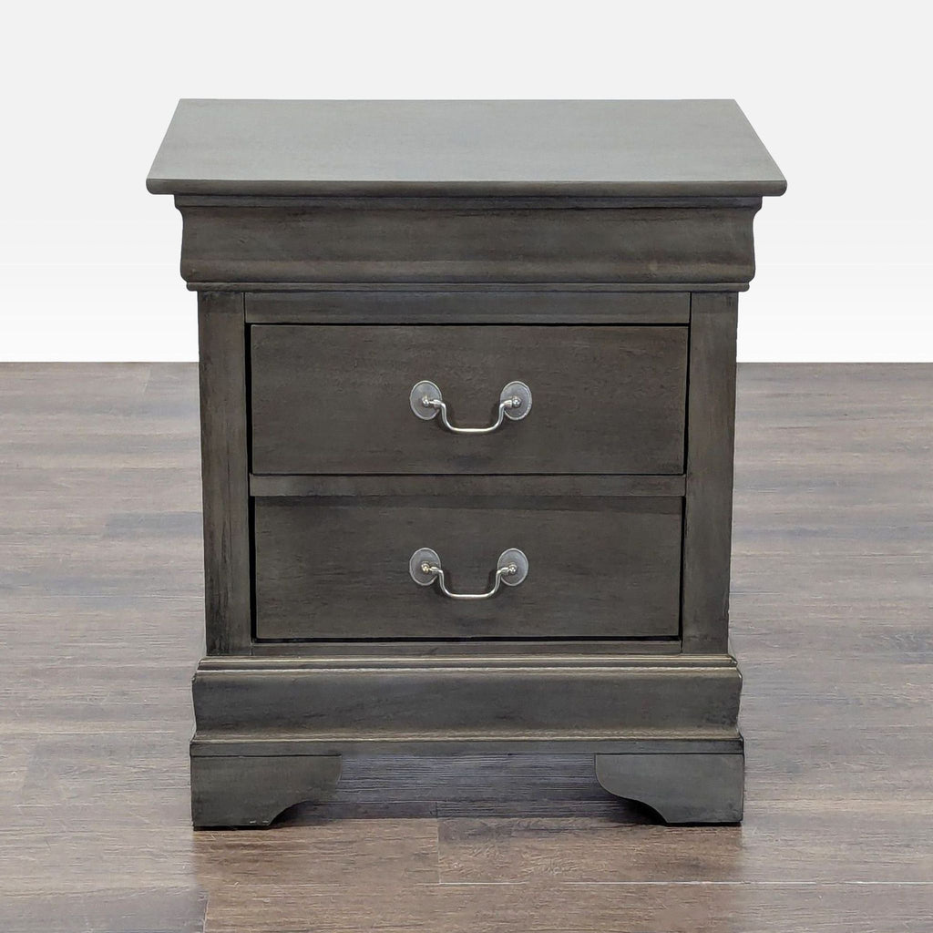 1. Front view of a dark wood end table with two drawers and silver handles, standing on a wooden floor.