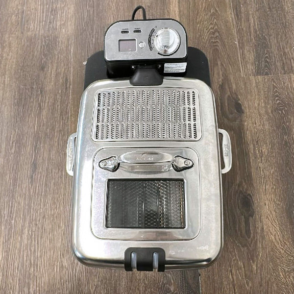 Stainless steel All-Clad deep fryer with digital controls and side handles, viewed with lid and viewing window.