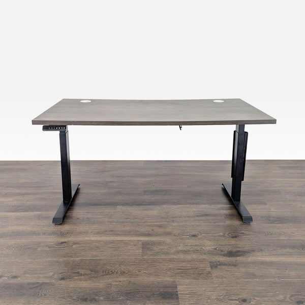 Modern electric standing desk with woodgrain surface and black frame, featuring cable grommets and under-desk tray.
