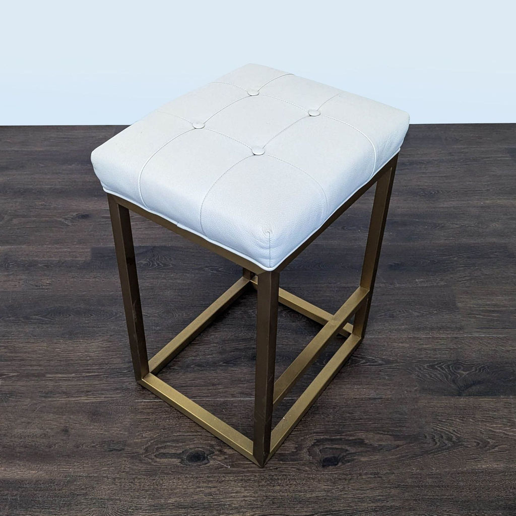 3. Button-tufted leather seat on metal base from Restoration Hardware, combining style and comfort.