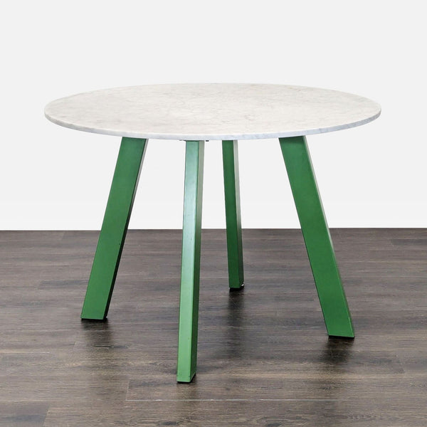Blu Dot dining table with a Carrara marble top and four sculptural powder-coated steel legs.