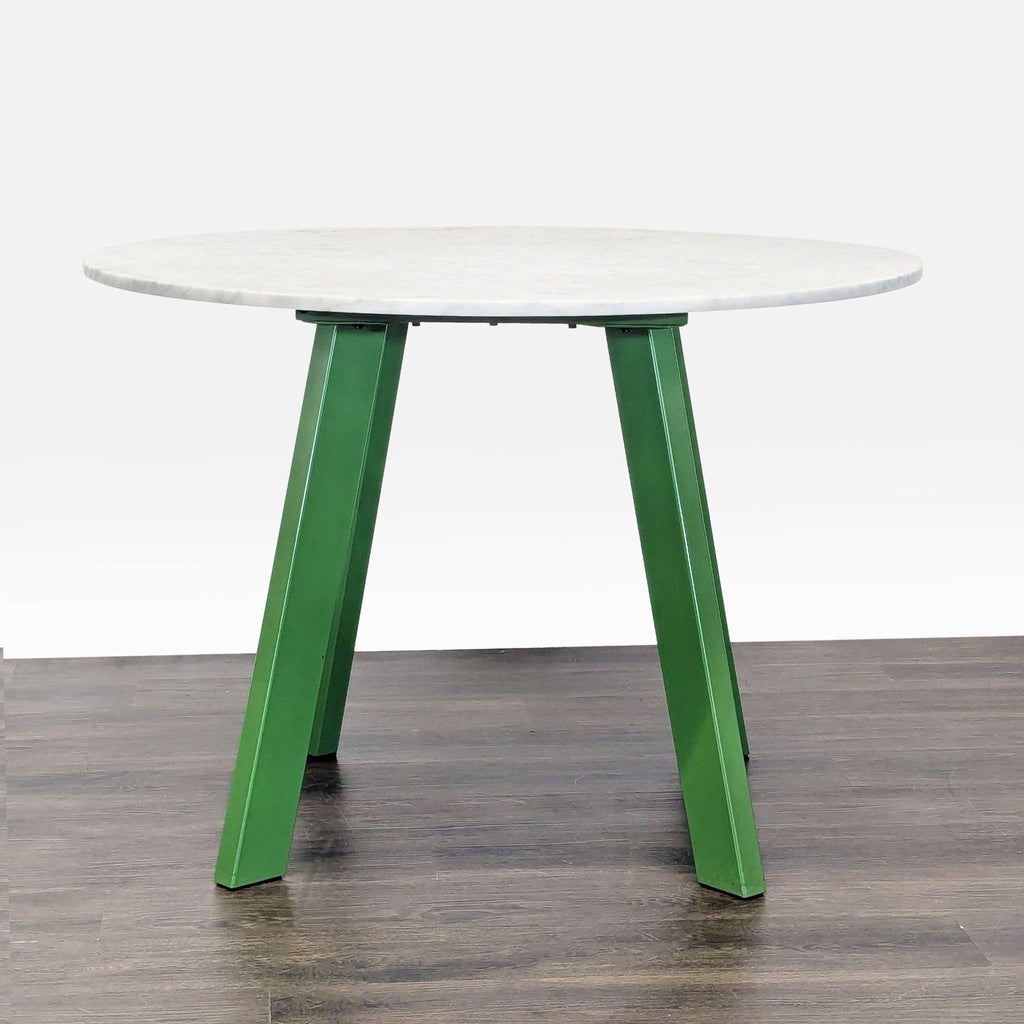 Modern dining table featuring a polished marble surface supported by artistic steel legs; brand: Blu Dot.