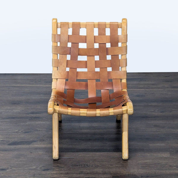 Lounge chair with a wooden frame and woven leather seat, blending modern and rustic styles.  