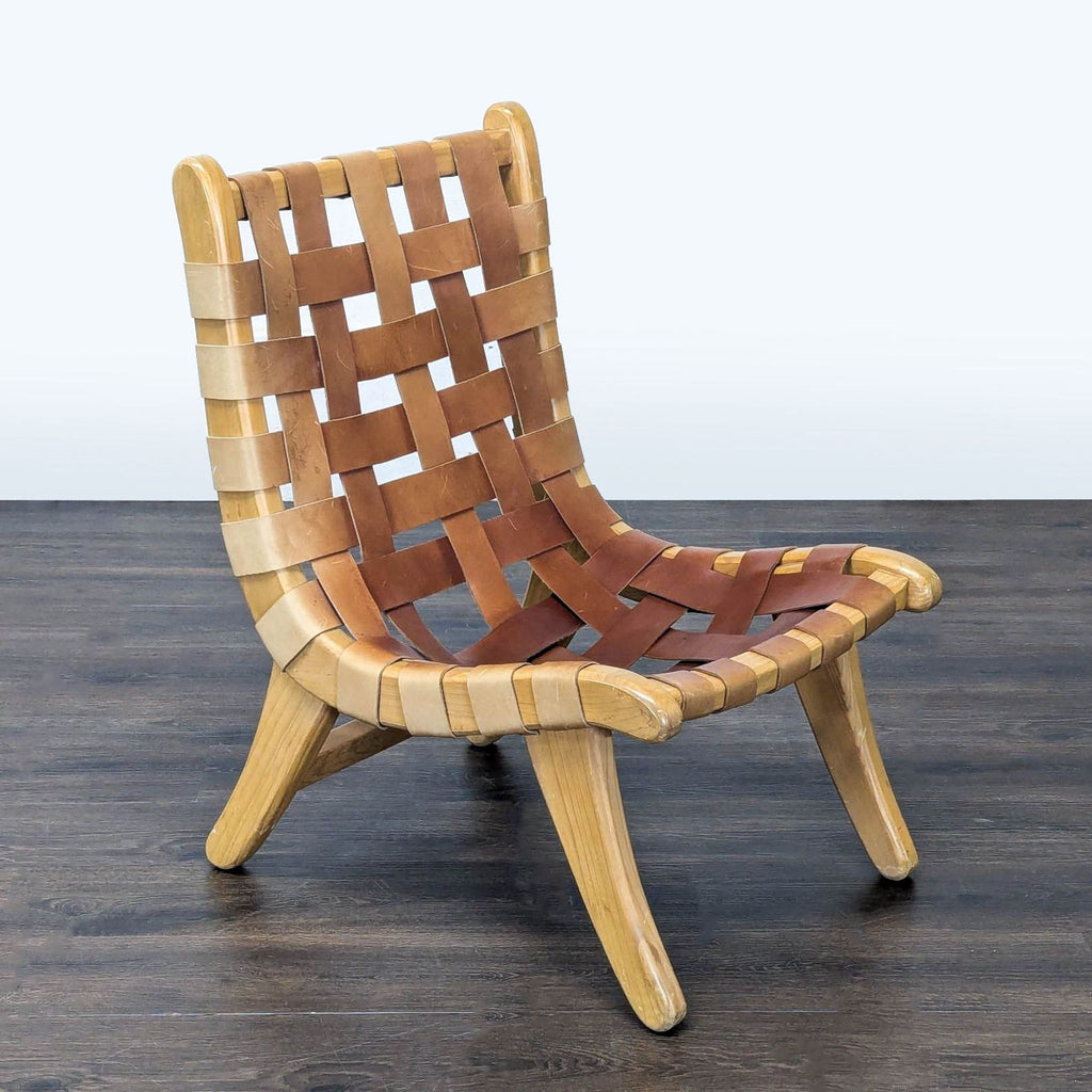 Modern lounge chair featuring gently curved wooden legs and soft woven leather straps for comfort.  