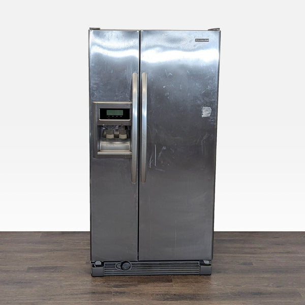 Stainless steel KitchenAid side-by-side refrigerator with ice and water dispenser, showing normal exterior wear.