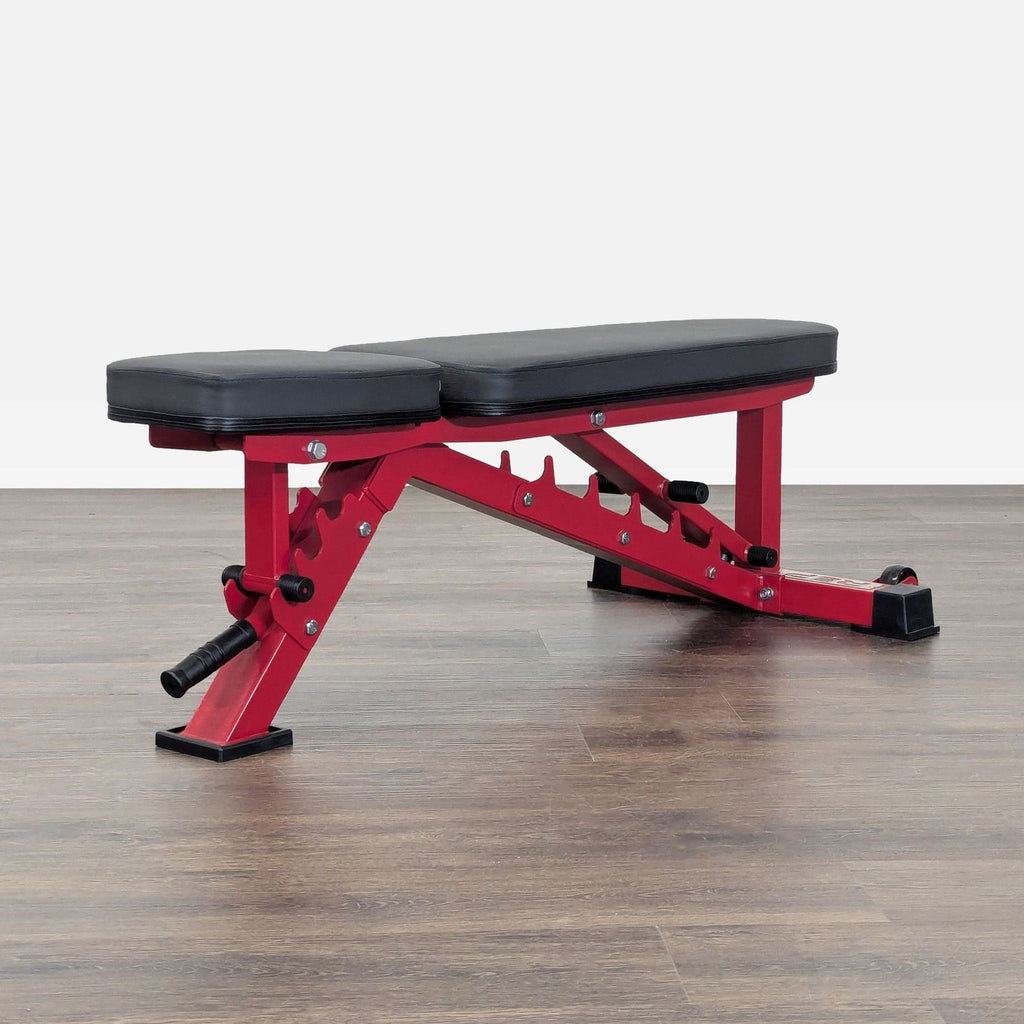 Sturdy REP Fitness gym bench featuring thick black padding, red frame, wheels, and a handle for mobility.