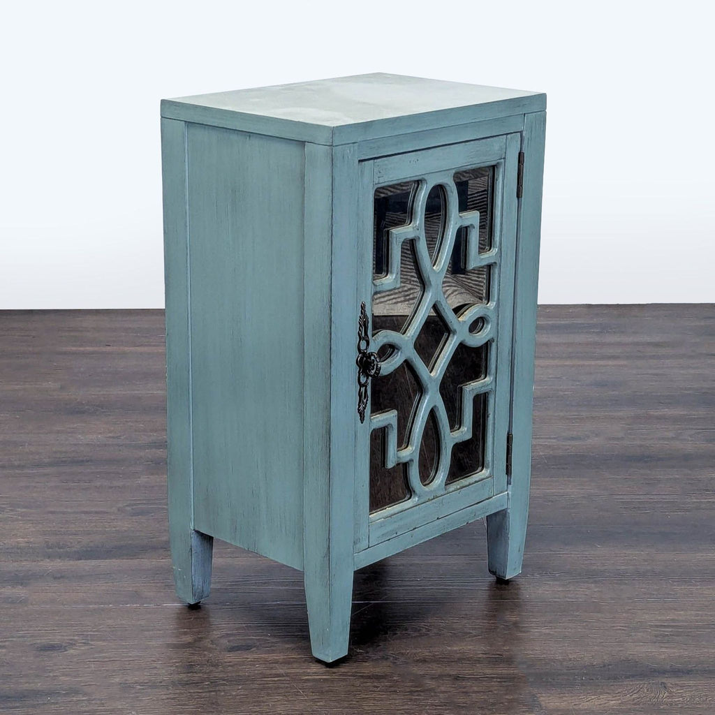 Leighton cabinet in turquoise with ornate mirrored door, fixed shelf inside, and rear wire management for media devices.