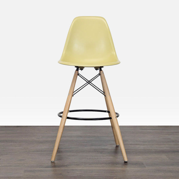 Mid-century stool with a molded plastic bucket seat, wood legs, and a metal footrest by Mod Made.