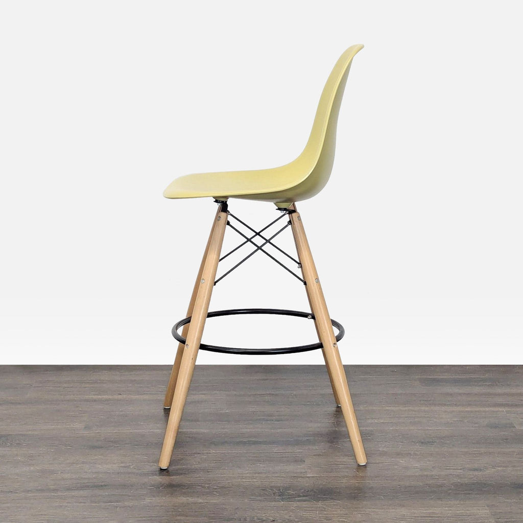 Contemporary Mod Made stool featuring a plastic bucket seat, sturdy wooden legs, and a circular metal footrest.