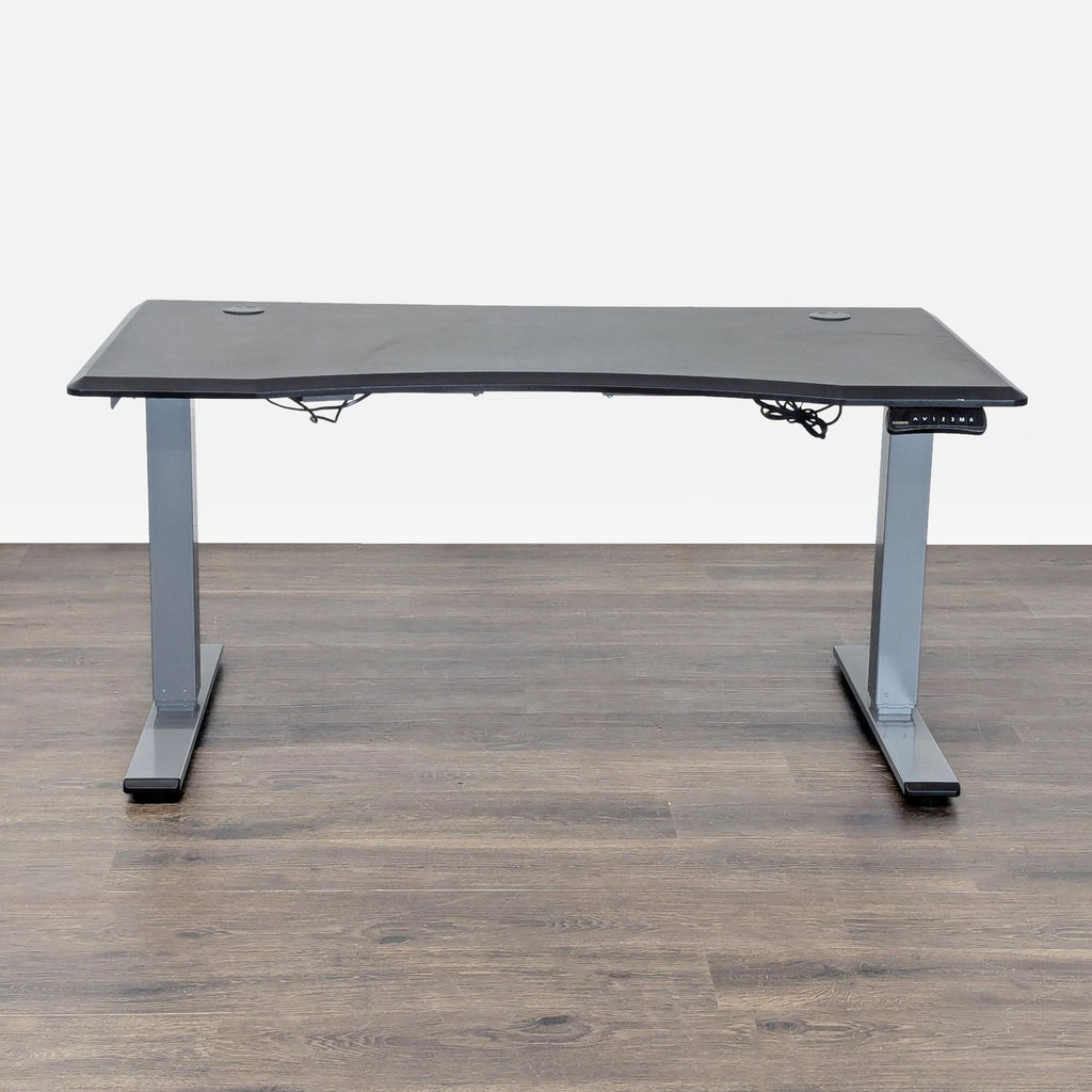 FlexiSpot electric standing desk with spacious black surface and digital control panel for adjustable height.  