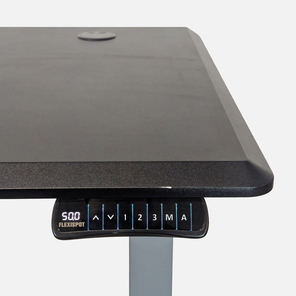 Black FlexiSpot sit-stand desk featuring memory presets and sturdy build, ideal for home or office use.  