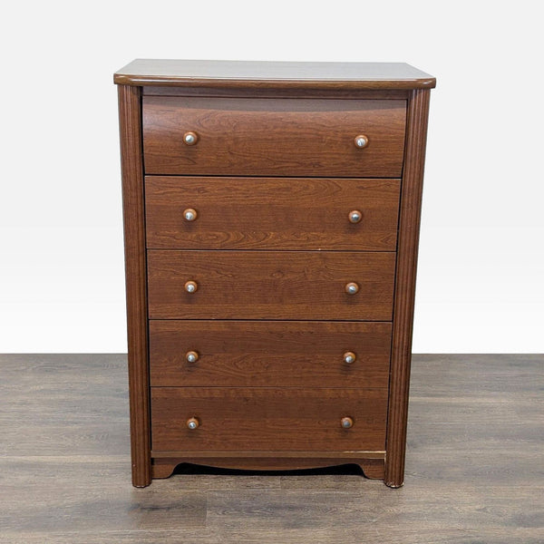 Brown wooden five-drawer dresser by Palliser Furniture with round knobs and classic design.