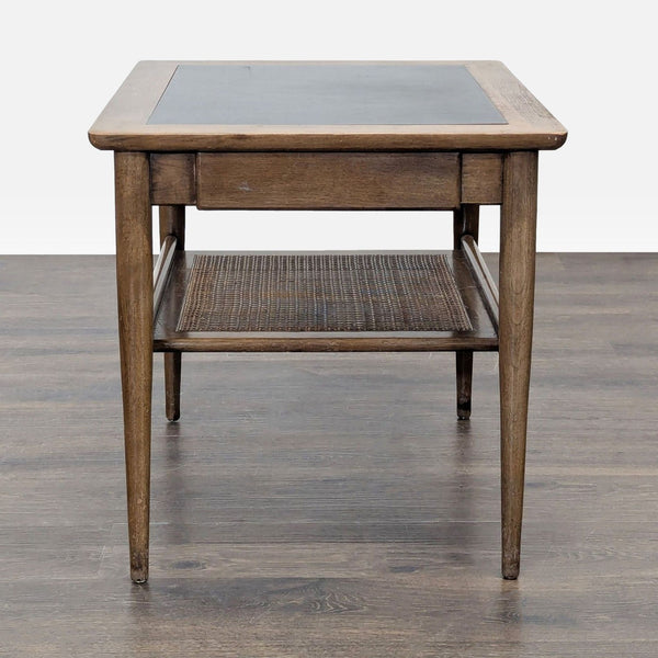 Mid-century walnut end table by American of Martinsville, with caned shelf, pull-out drawer, and black micarta top.