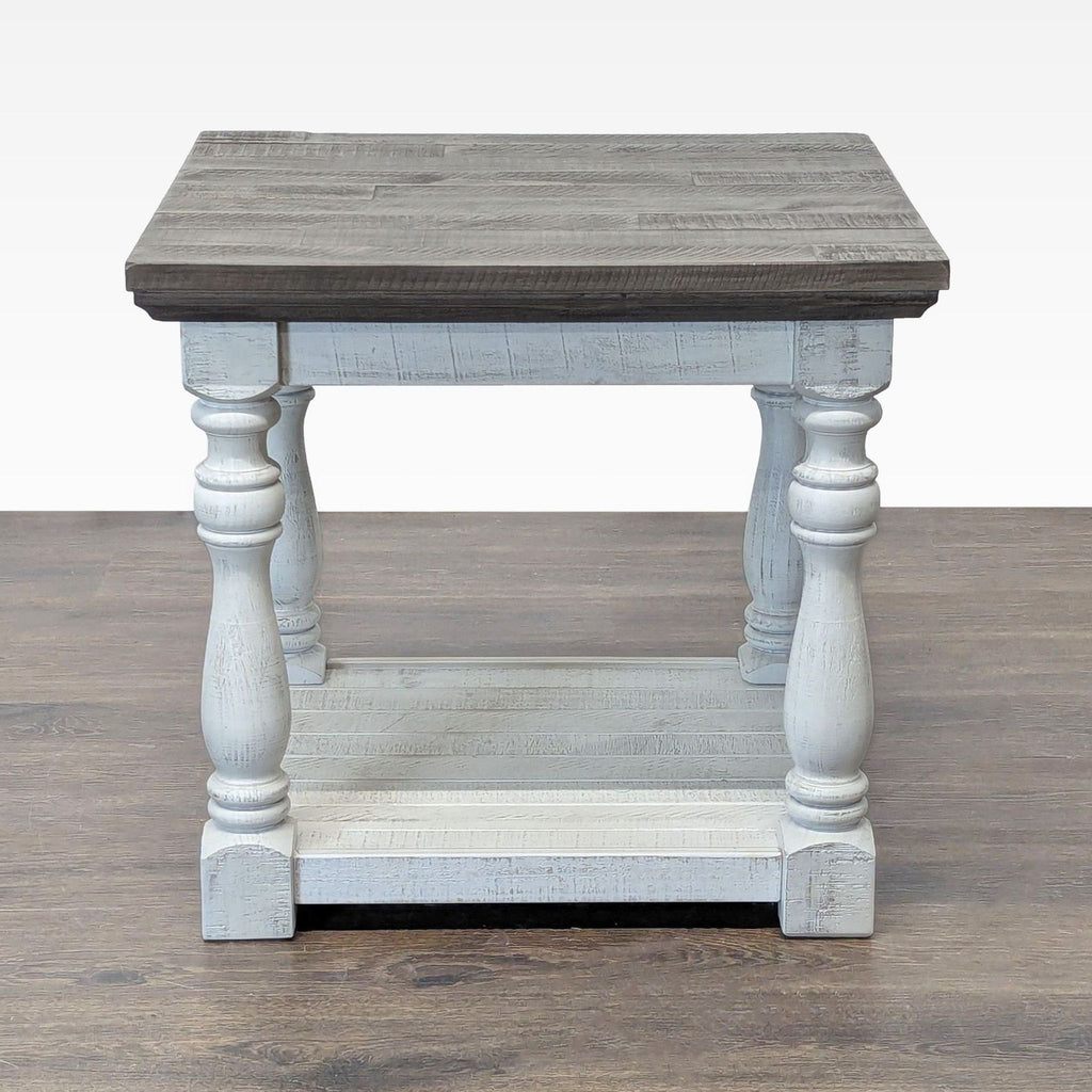 Two tone farmhouse style end table by Ashley Furniture with turned legs and bottom shelf, shown front view.  