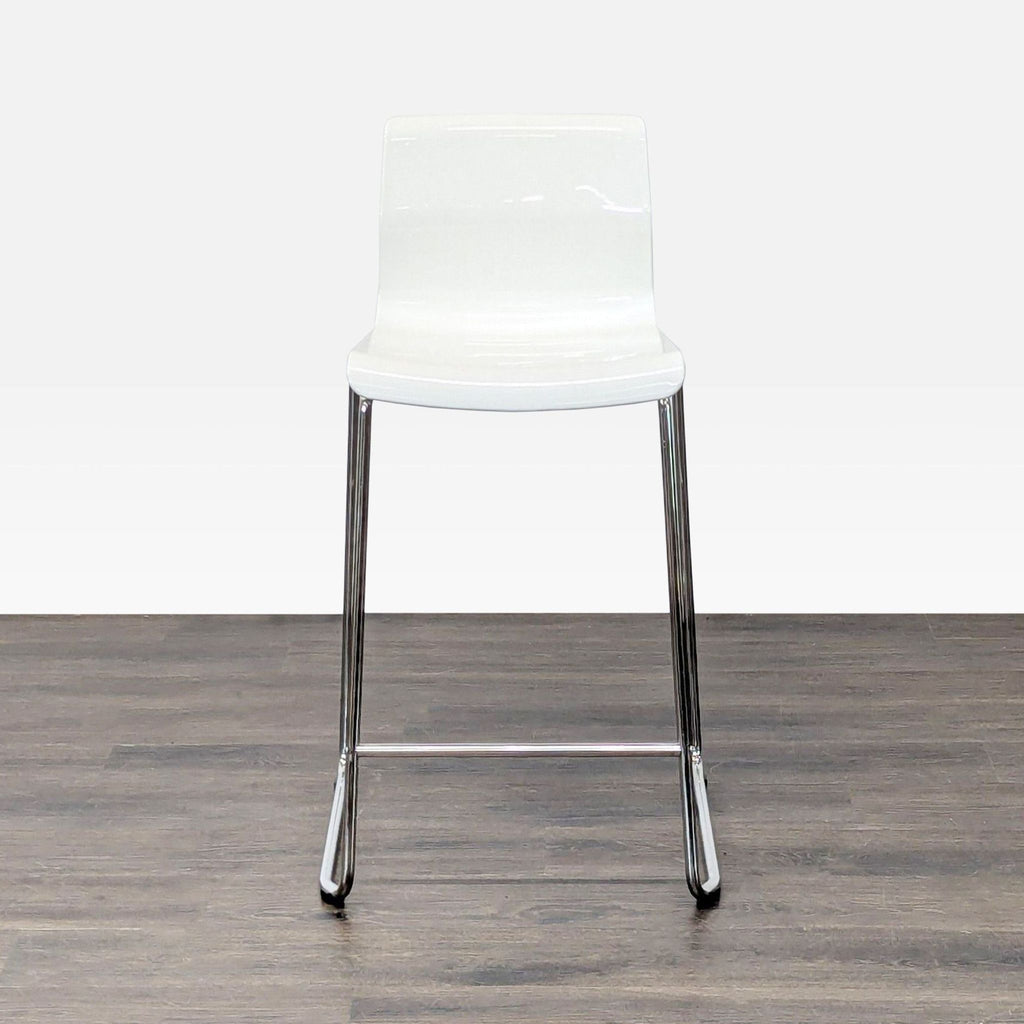 Minimalist Ikea stool with a plastic seat and metal frame, ideal for modern interiors.