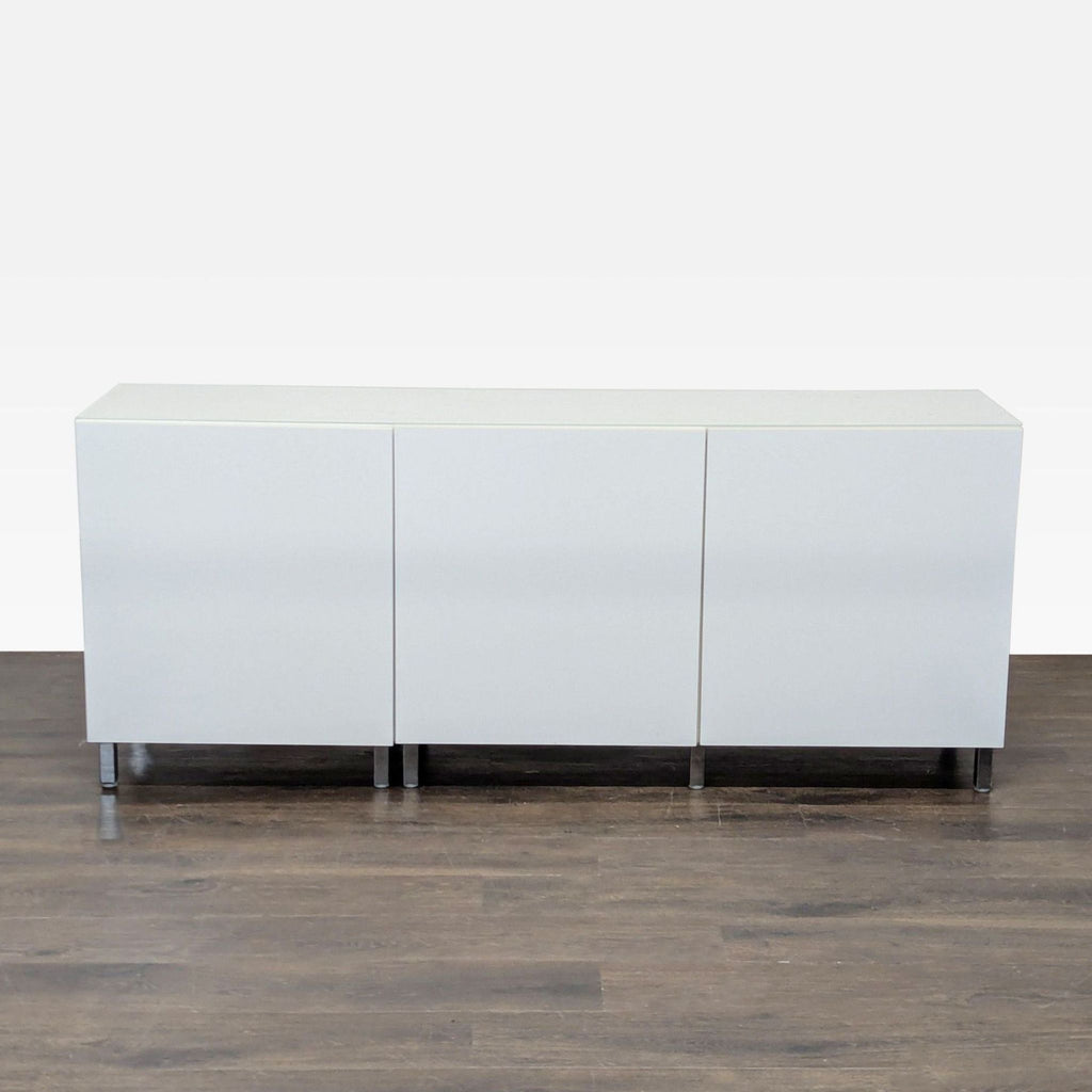 Sleek white office cabinet with three doors, adjustable shelves, and sturdy metal legs for organized storage.