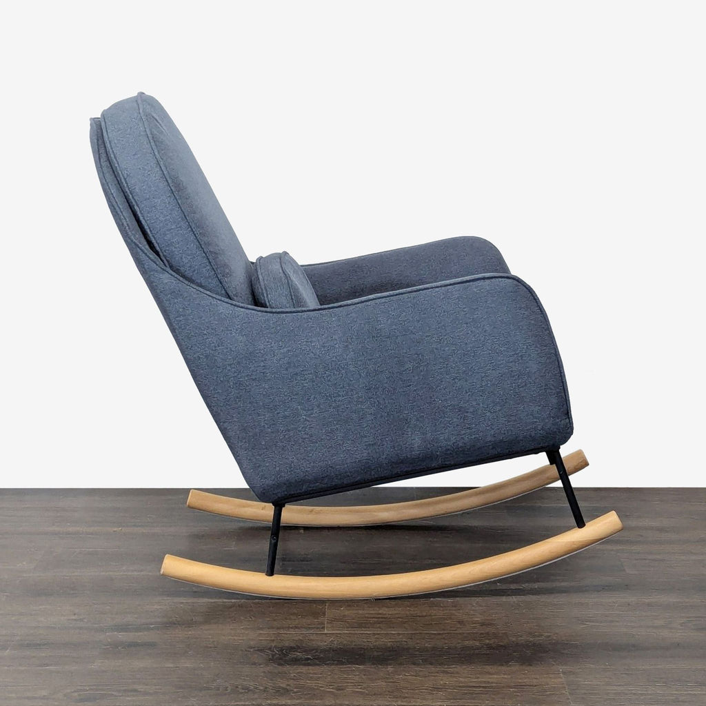 Modern nursery chair from Delta Children with soft blue upholstery, supportive cushioning, and smooth wooden rocker base.