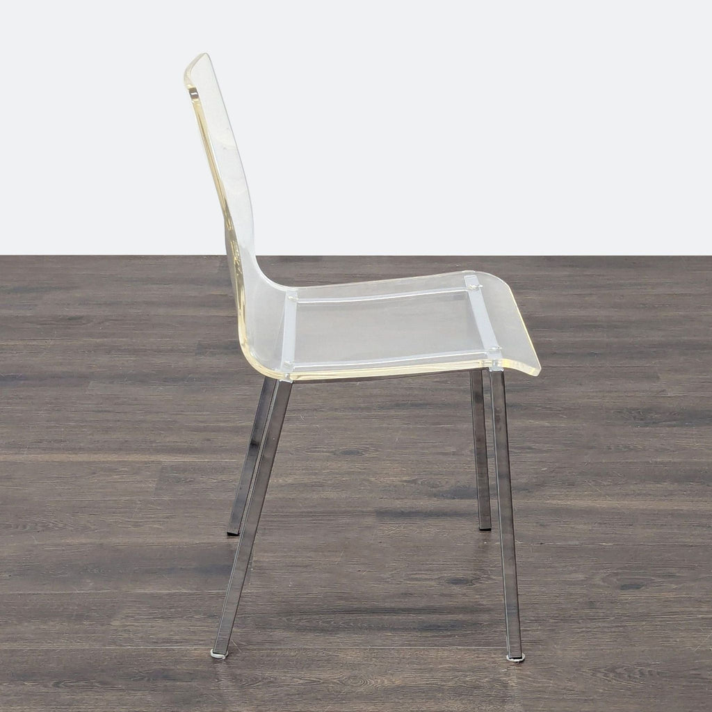 2. Side view of a transparent dining chair with a modern plastic seat and shiny chrome legs.